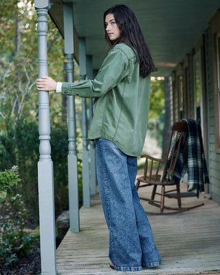 woman on porch in oversized workshirt