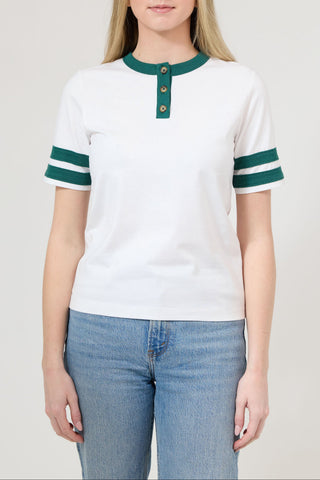 Person wearing a white and green striped shirt with blue jeans on a plain background