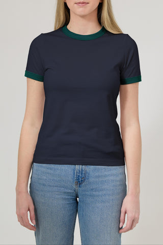 Person wearing a navy blue t-shirt with green trim on a plain background
