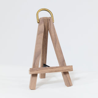 Wooden easel with a gold handle on a white background