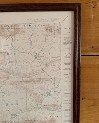 A framed vintage topographical map of the Arkansas Indian Territory, featuring a dark brown wooden frame and a light wood background.