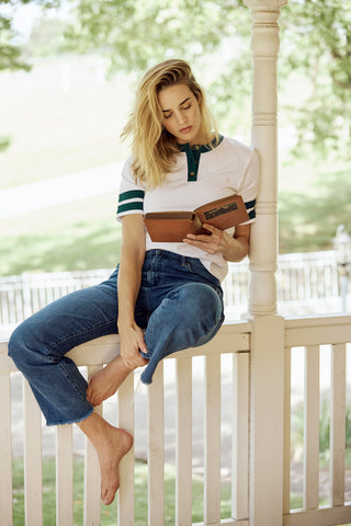 Woman sitting on a porch reading a book