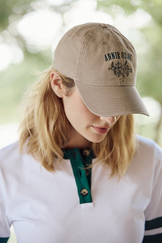 Person wearing a beige cap with 'Annie Ozark' branding outdoors