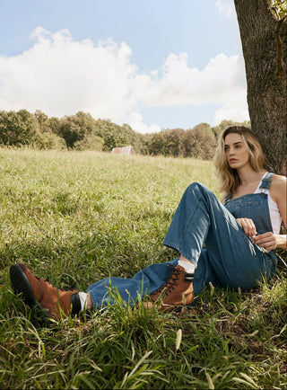 Woman sitting under a tree in a grassy field